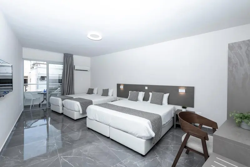 Une chambre lumineuse avec deux lits doubles et une chaise.