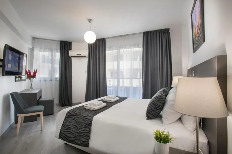 Une chambre lumineuse avec un grand lit et une fenêtre.