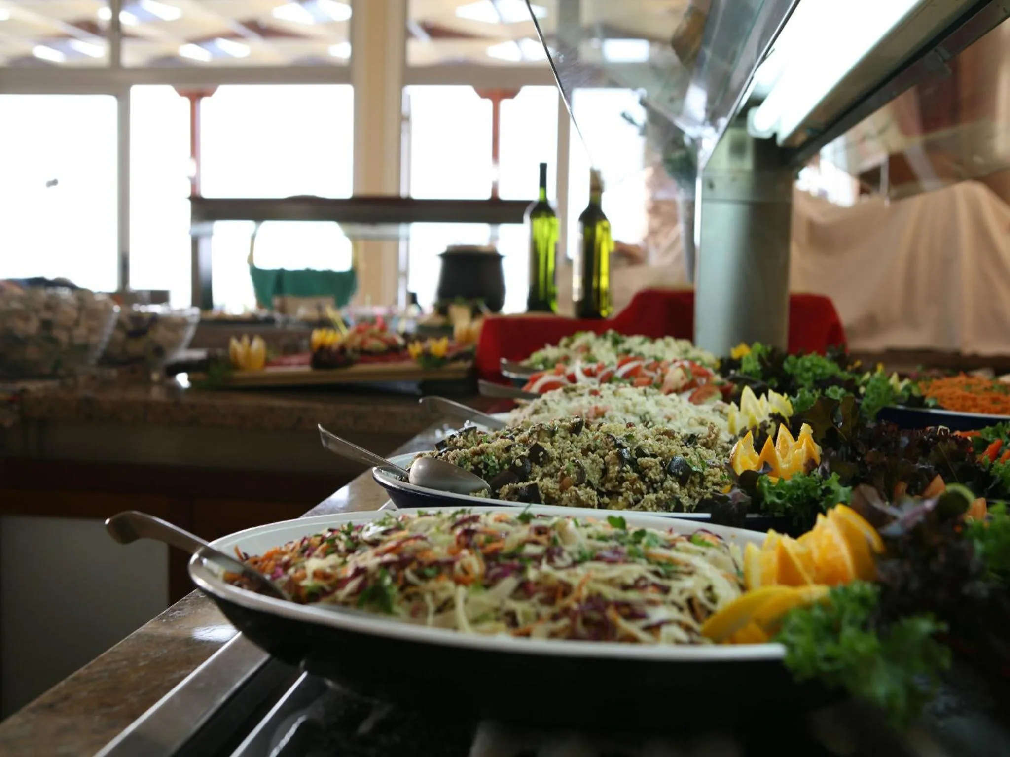 Un buffet propose une variété de salades et de plats froids.