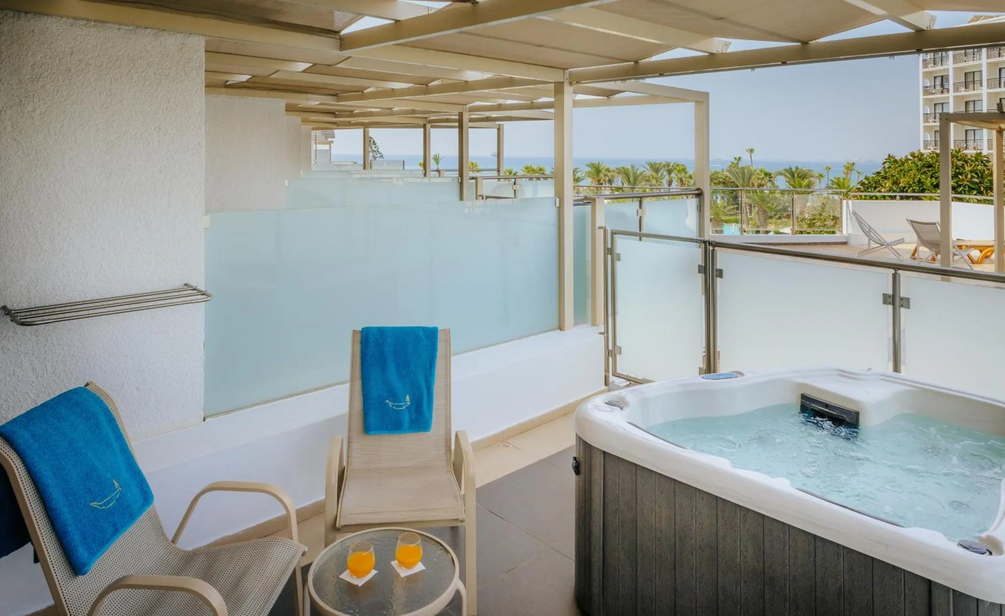 Terrasse avec jacuzzi et mobilier de détente offrant une vue sur la mer.