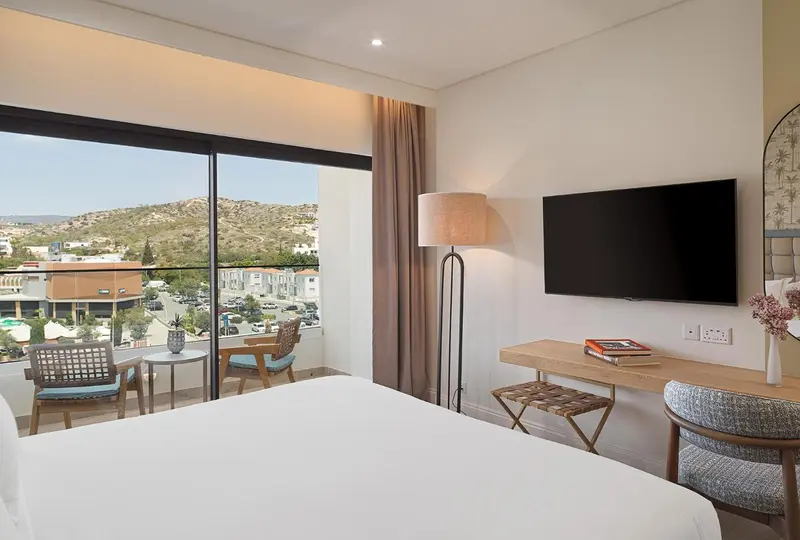 Une chambre lumineuse avec un grand lit et une vue sur un paysage montagneux.