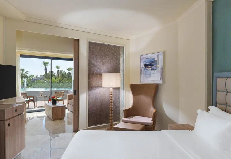 Une chambre lumineuse s'ouvre sur une terrasse avec mobilier.
