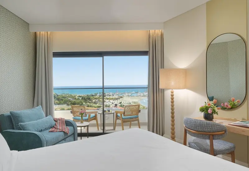 Chambre lumineuse avec vue sur la mer et balcon aménagé.