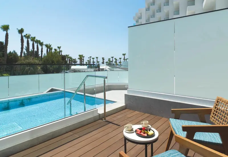 Une terrasse avec une petite piscine et une table basse.