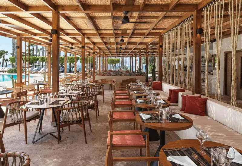 Une salle à manger extérieure avec des tables et des chaises en bois.