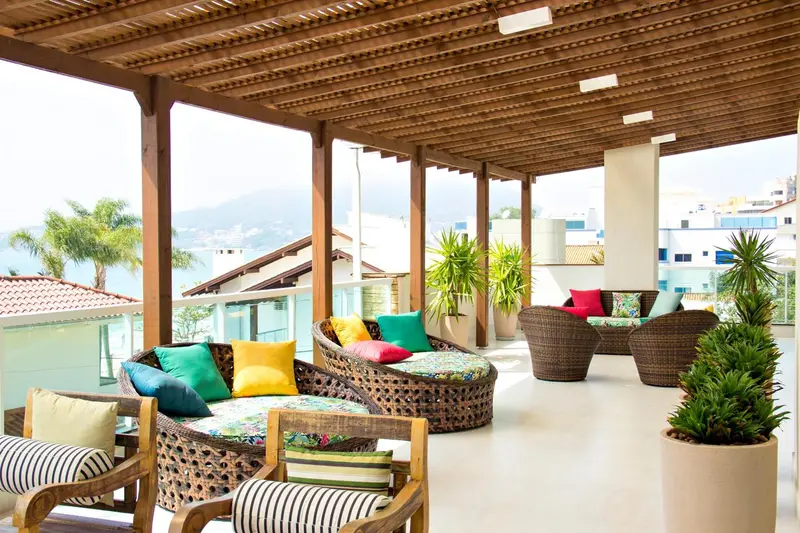 Espace de détente extérieur avec mobilier en rotin et coussins colorés.