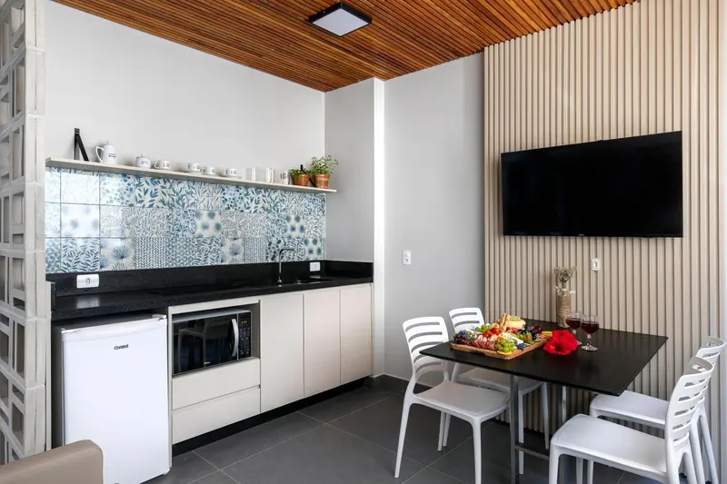 Une cuisine moderne s'ouvre sur un coin repas avec une table et des chaises.