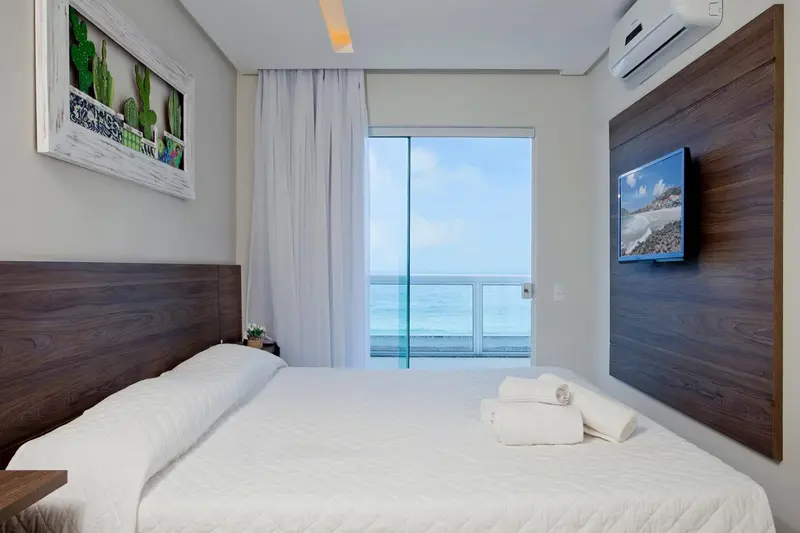 Une chambre lumineuse avec un grand lit et une vue sur la mer.