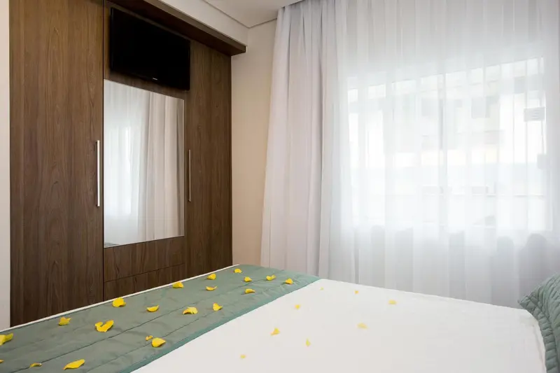 Une chambre décorée avec un lit et un meuble de rangement.