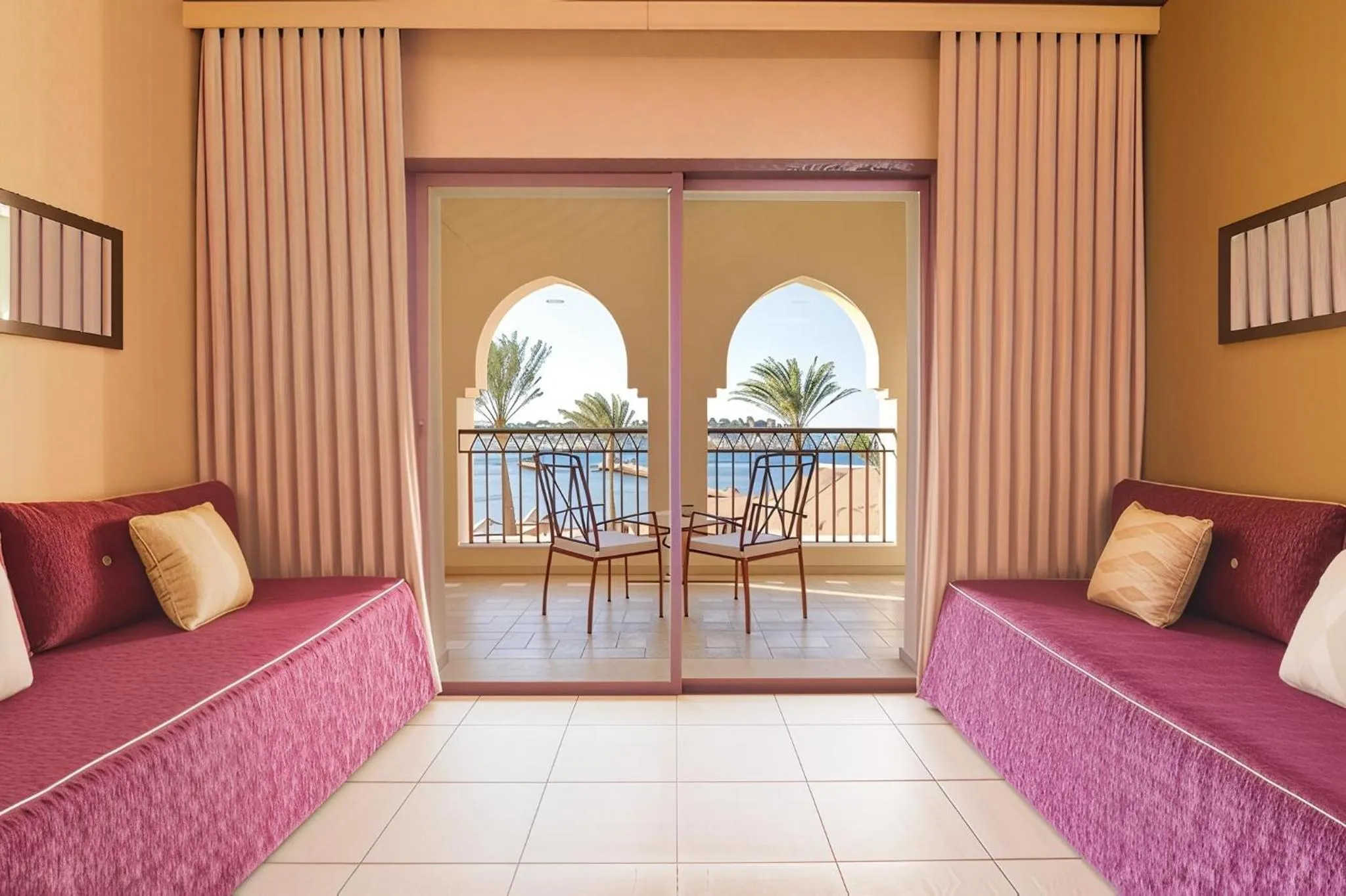 Espace de détente avec canapés et accès à un balcon donnant sur la mer.