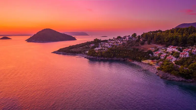 Vue aérienne d'un complexe hôtelier au bord de la mer au coucher du soleil.