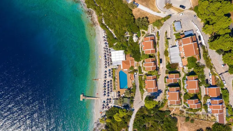 Vue aérienne d'un complexe hôtelier avec plage et parasols.