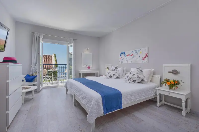 Une chambre lumineuse avec un grand lit et un accès à un balcon.