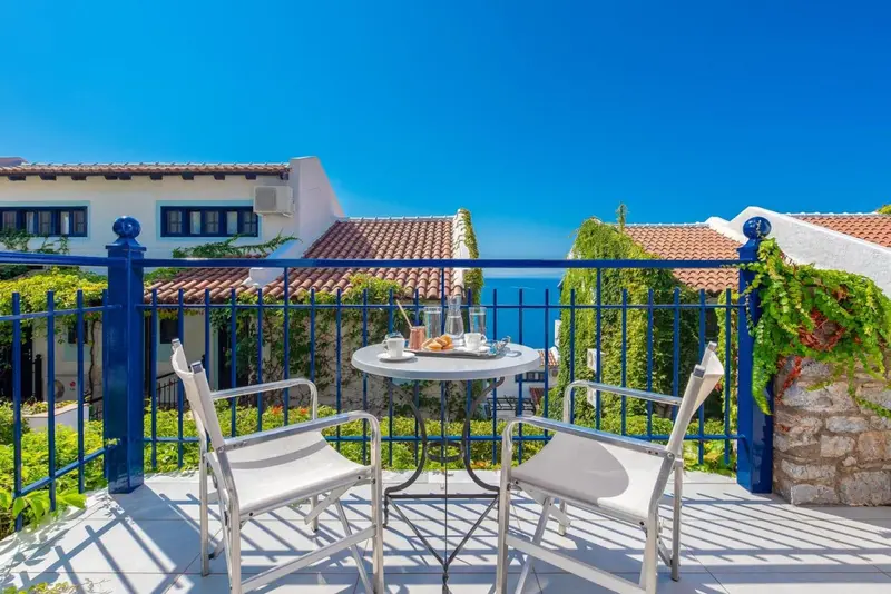 Terrasse avec table et chaises donnant sur la mer.