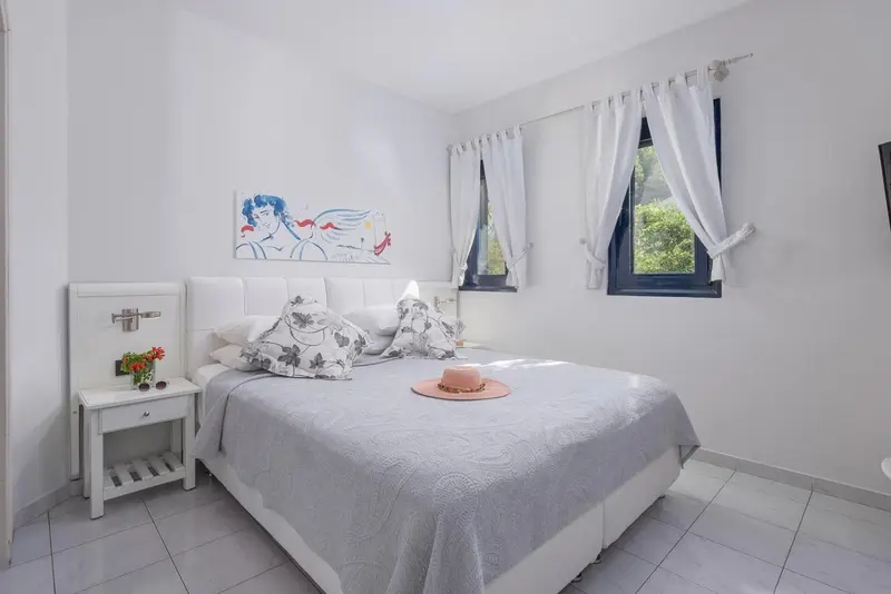 Une chambre lumineuse avec un grand lit et une décoration florale.