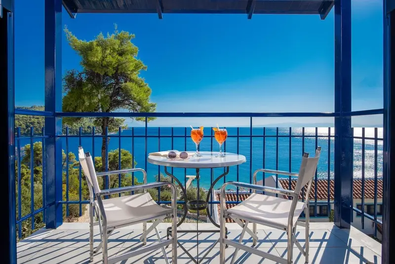 Une terrasse avec une table et des chaises offre une vue sur la mer.