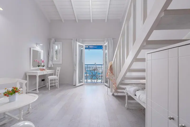 Une chambre lumineuse avec un lit mezzanine et une vue sur la mer.