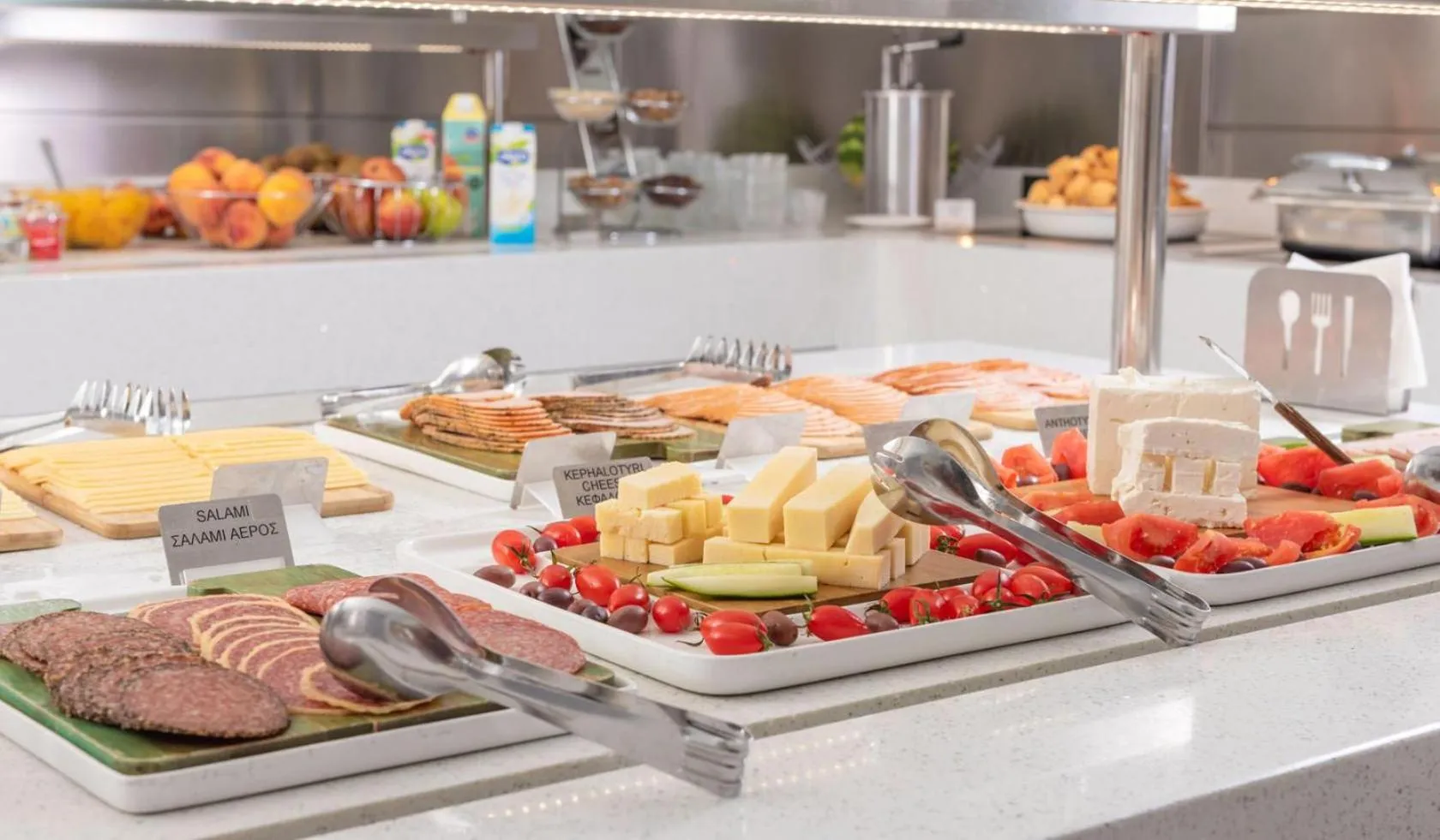 Un buffet propose une variété de charcuteries, de fromages et de légumes frais.
