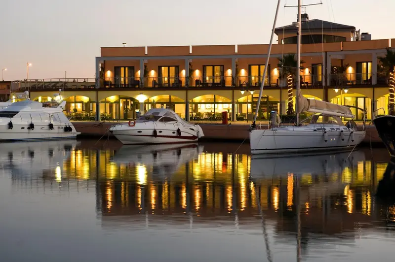 Bateaux de plaisance amarrés dans un port au coucher du soleil.