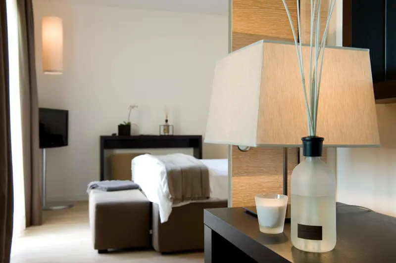 Une chambre lumineuse avec un lit fait et une décoration sobre.