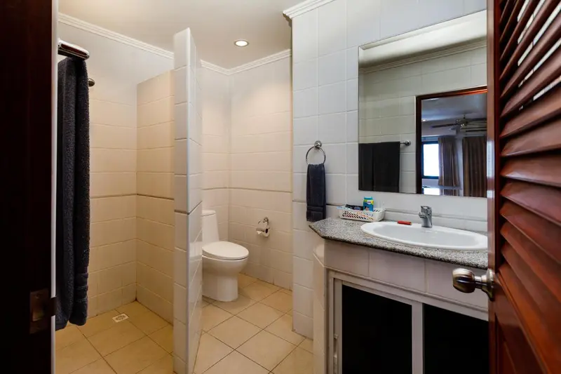 Une salle de bain claire avec douche, lavabo et toilettes.