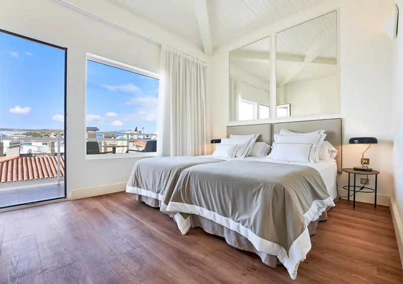 Une chambre lumineuse avec un grand lit et une vue sur la mer.