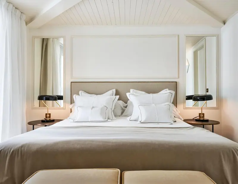 Un lit double avec des oreillers blancs dans une chambre lumineuse.