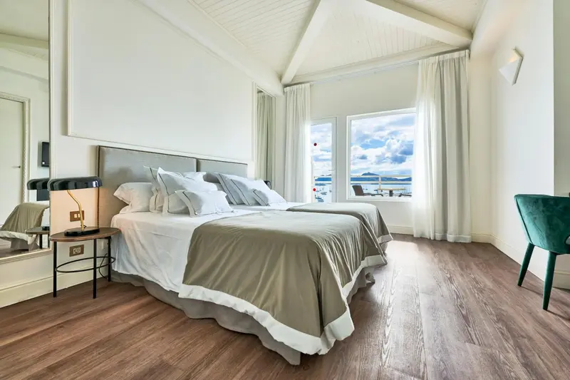 Une chambre lumineuse avec un grand lit et une vue sur la mer.