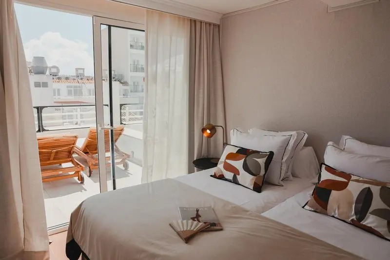 Une chambre lumineuse avec un grand lit et un accès à une terrasse.