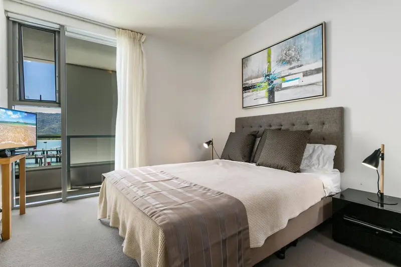 Une chambre lumineuse avec un grand lit et une décoration sobre.