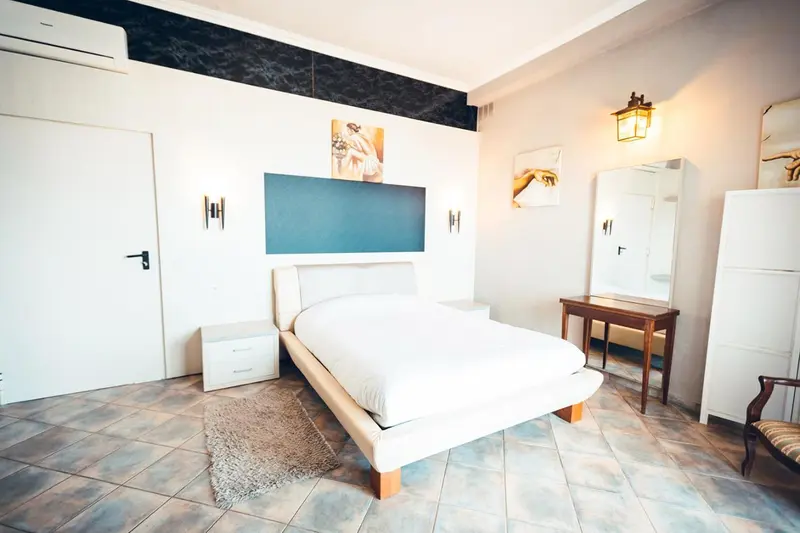 Une chambre lumineuse avec un grand lit et un décor mural.