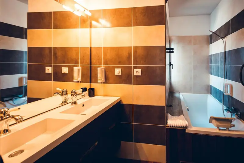 Une salle de bain moderne avec carrelage rayé et baignoire.