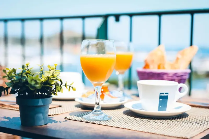 Une table est dressée avec un petit-déjeuner face à la mer.