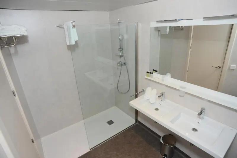 Une salle de bain moderne avec douche à l'italienne et double vasque.