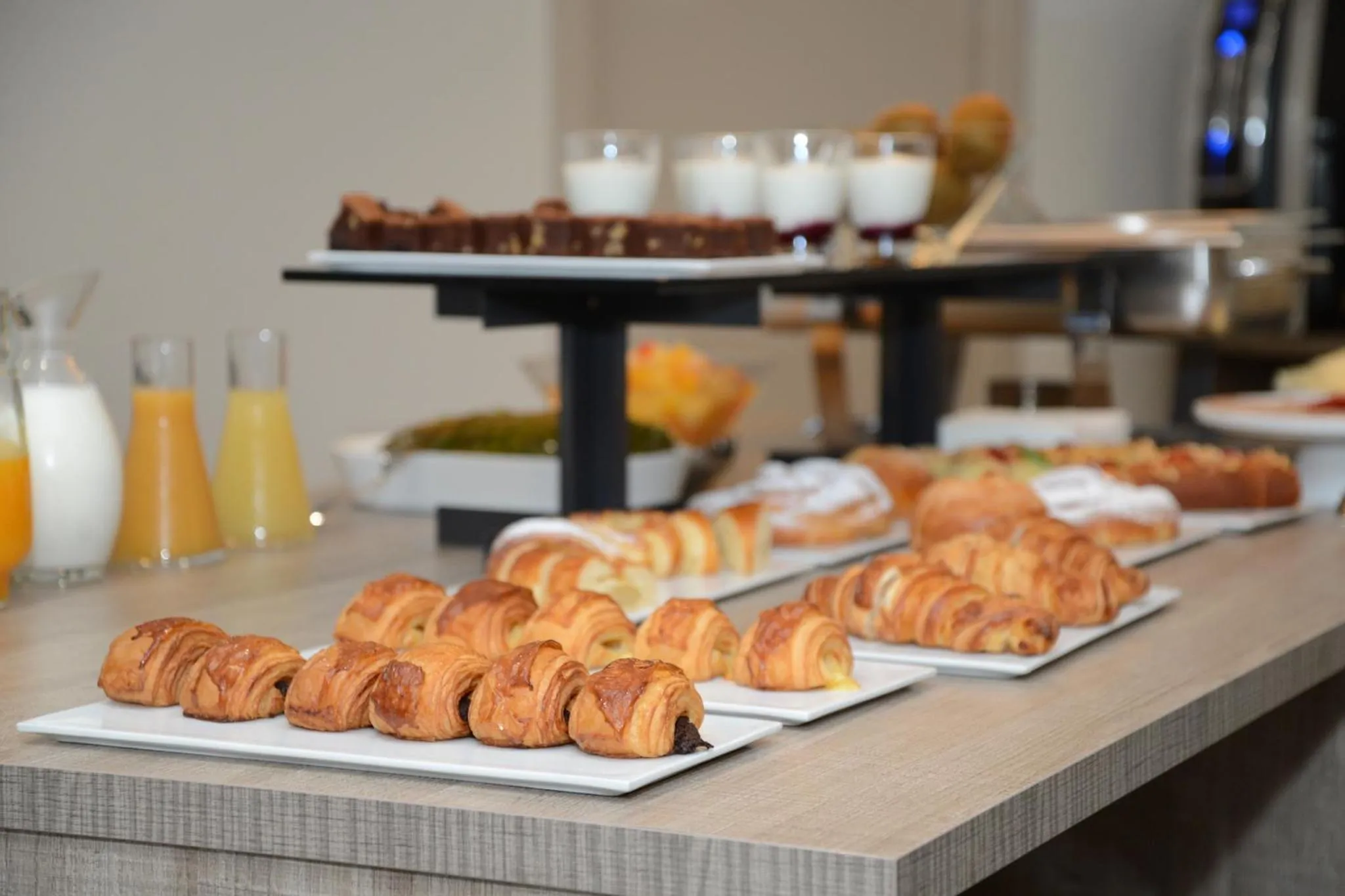 Une table présente une variété de viennoiseries et de boissons.