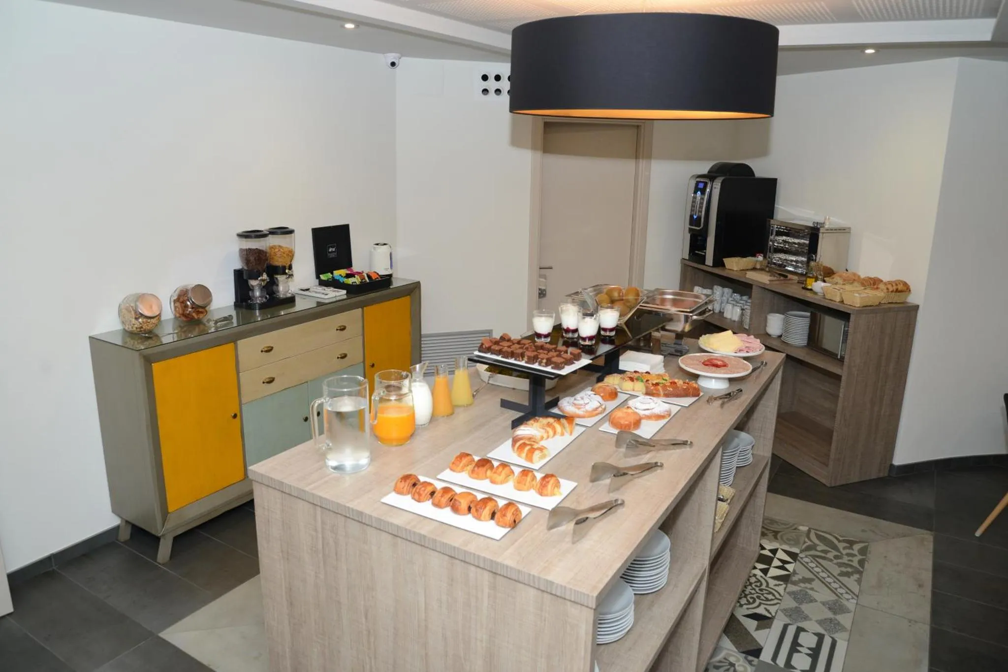 Un buffet propose des viennoiseries, des céréales et des boissons.