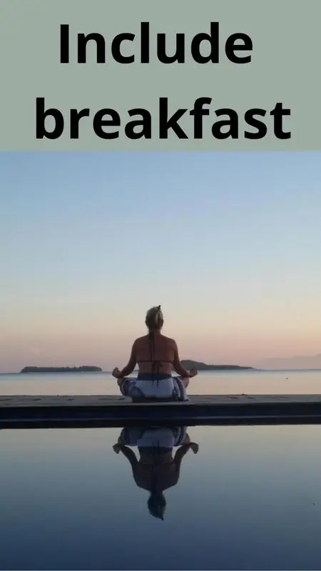 Une personne est assise en tailleur au bord d'une piscine avec une vue sur la mer au loin.