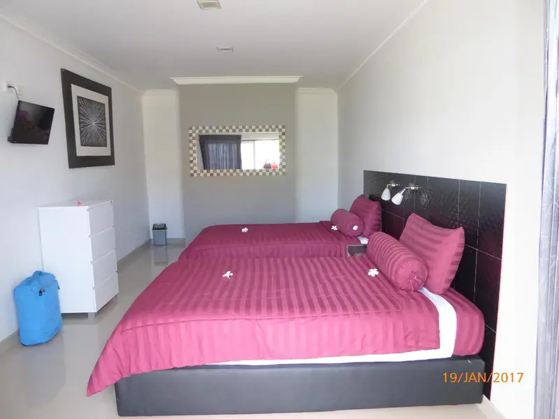 Une chambre avec un grand lit et une décoration sobre.