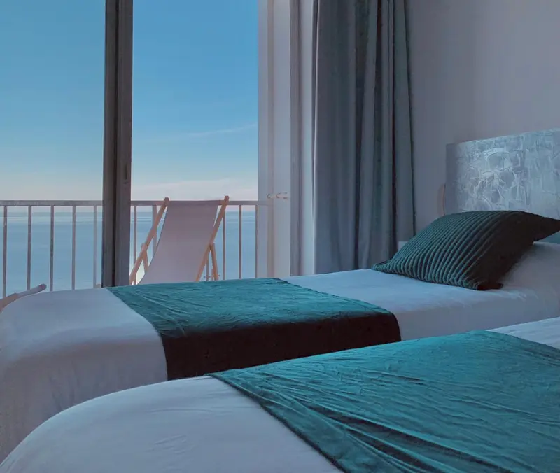 Une chambre avec un grand lit donnant sur une vue mer.