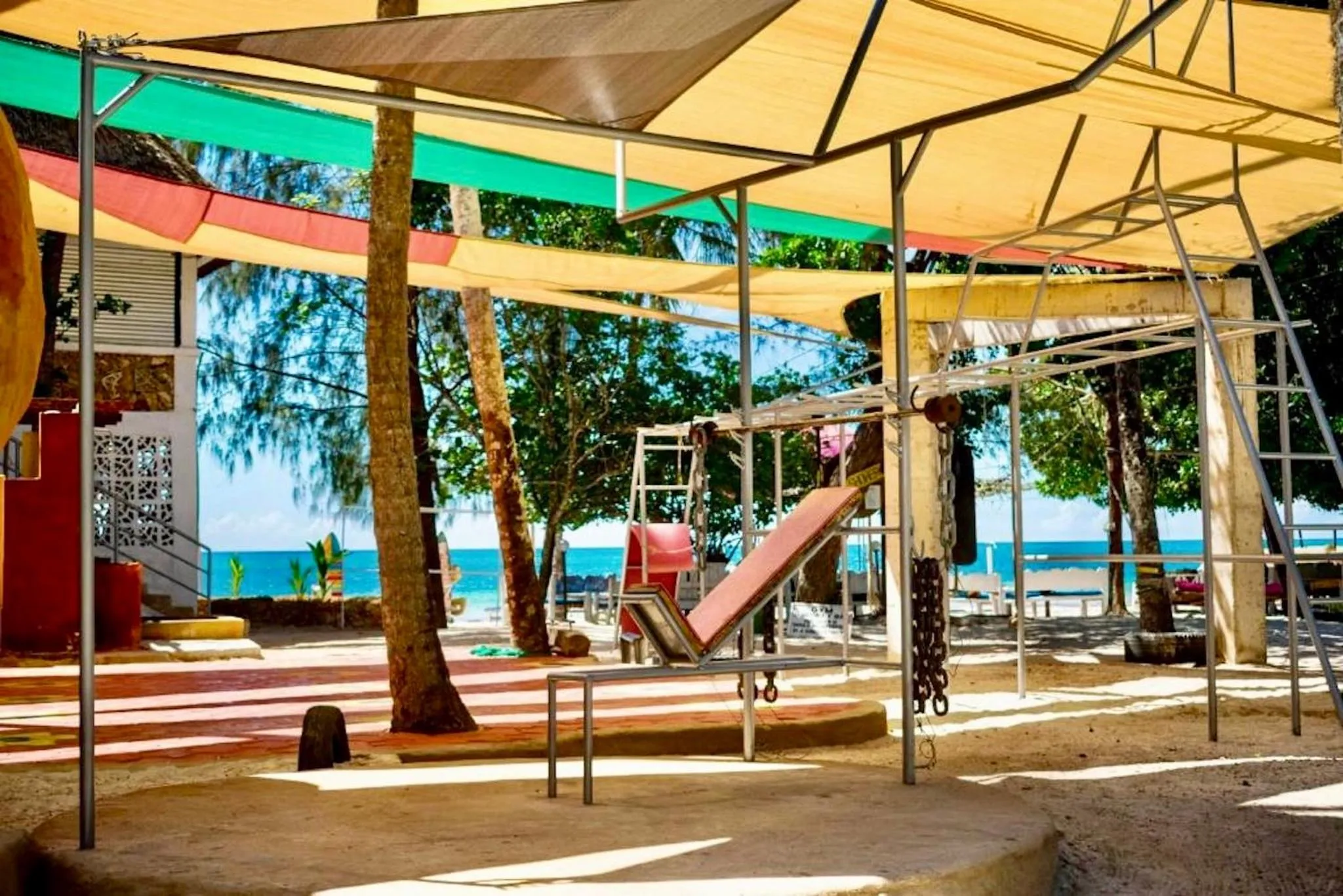 Espace ombragé avec des transats et une vue sur la mer.
