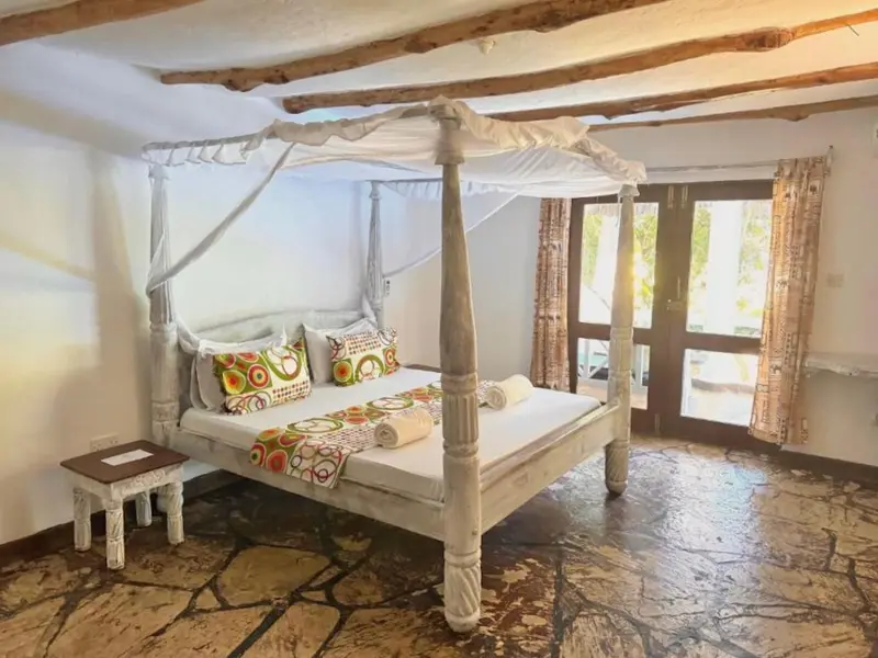 Une chambre lumineuse avec un lit à baldaquin et une décoration colorée.
