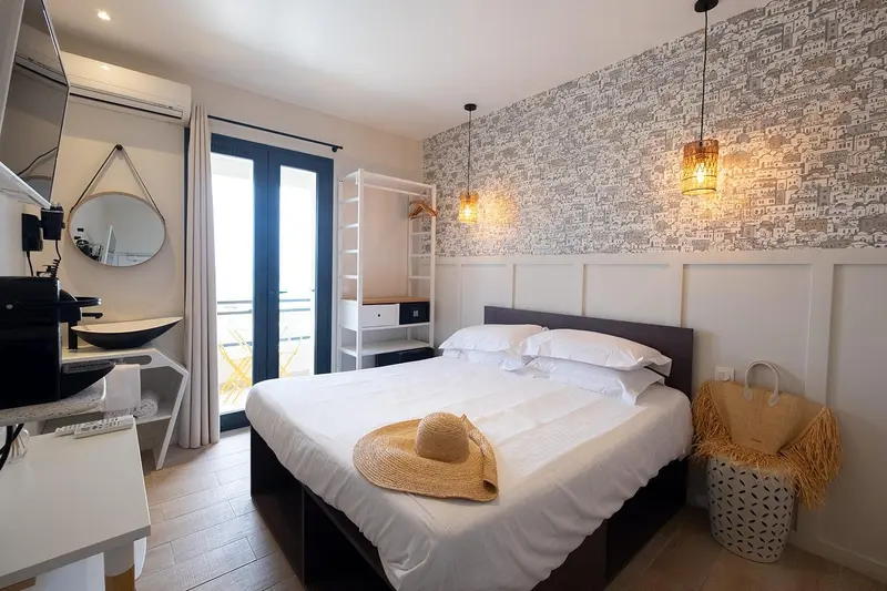 Une chambre lumineuse avec un lit double et un accès à une terrasse.