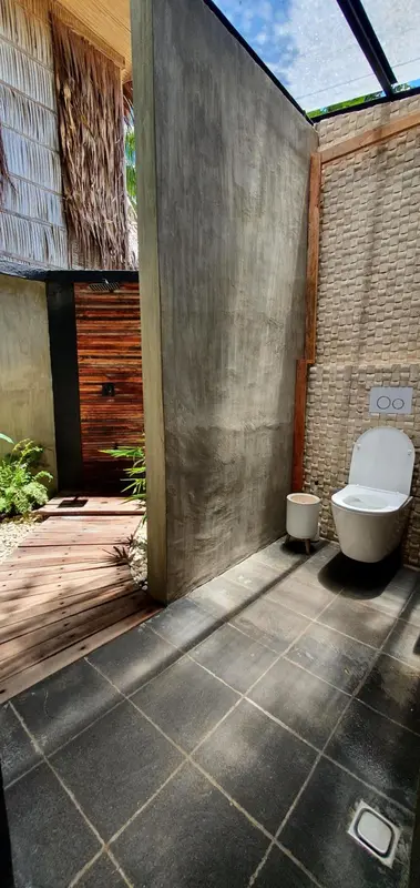 Une salle de bain moderne avec douche extérieure et toilettes.