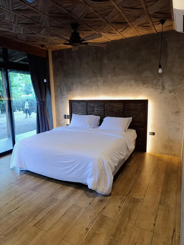 Une chambre lumineuse avec un grand lit recouvert de draps blancs.