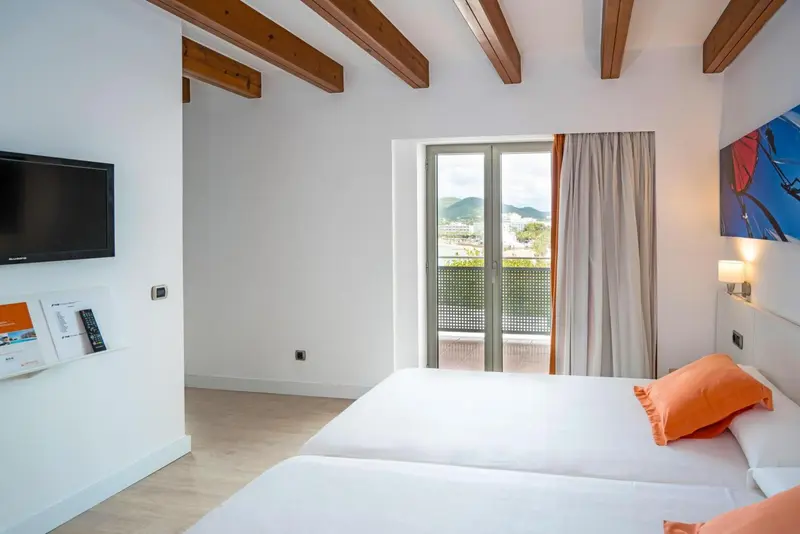 Chambre lumineuse avec un lit double et une vue sur le paysage.