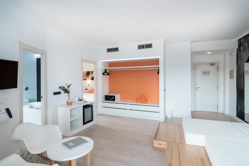 Une chambre lumineuse avec un espace détente et un dressing intégré.