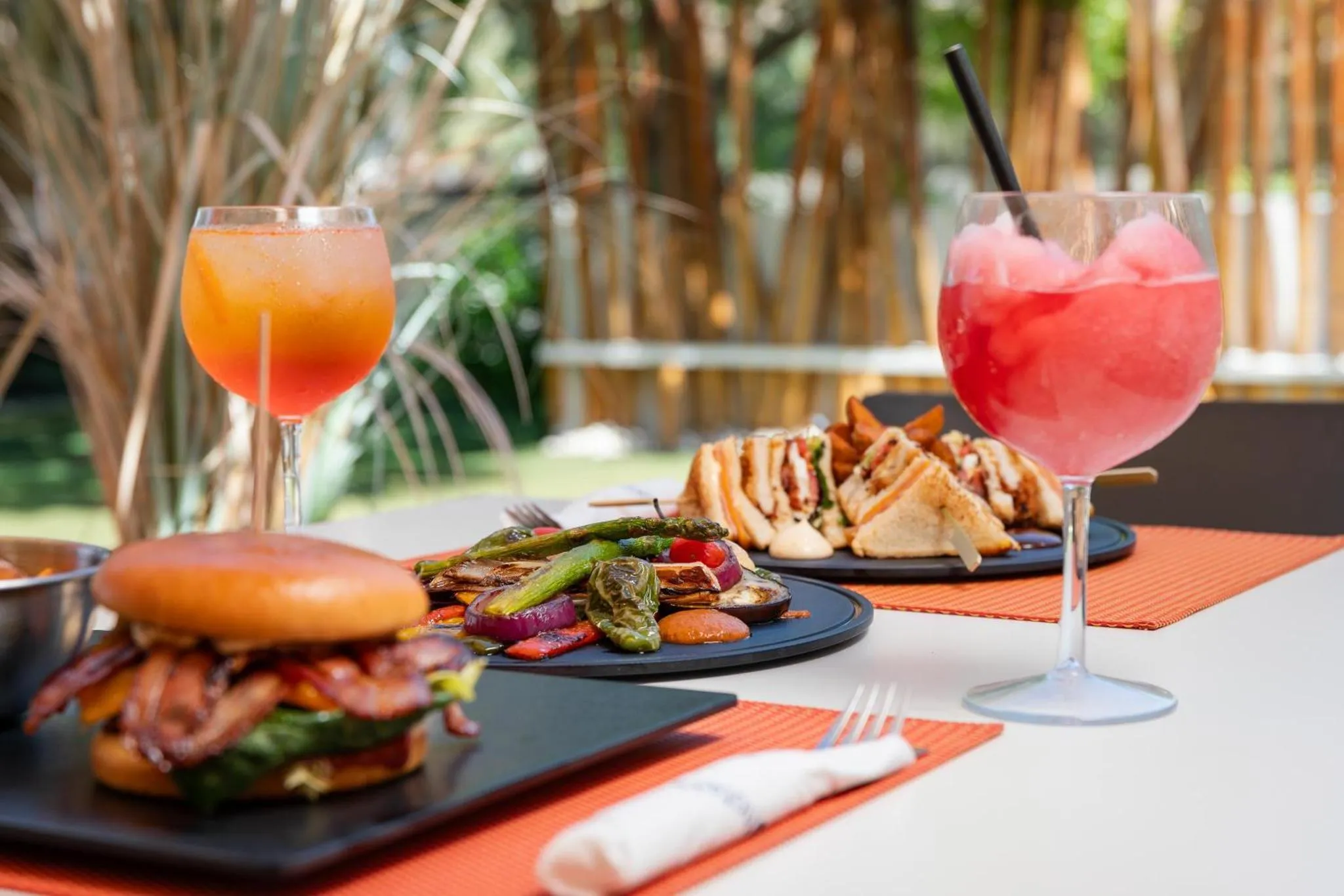 Une table est dressée avec des plats colorés et des boissons rafraîchissantes.