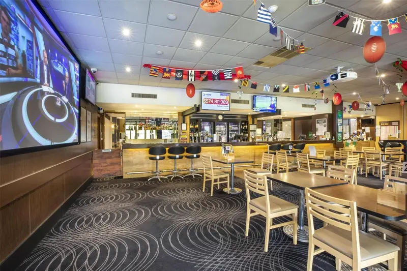 Une salle spacieuse avec un comptoir de bar et des tables.