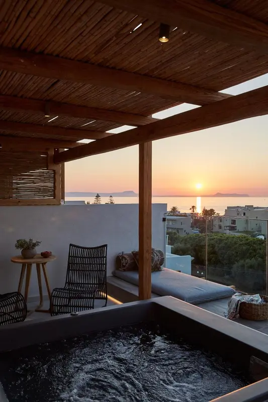 Terrasse avec jacuzzi et vue sur le coucher de soleil.