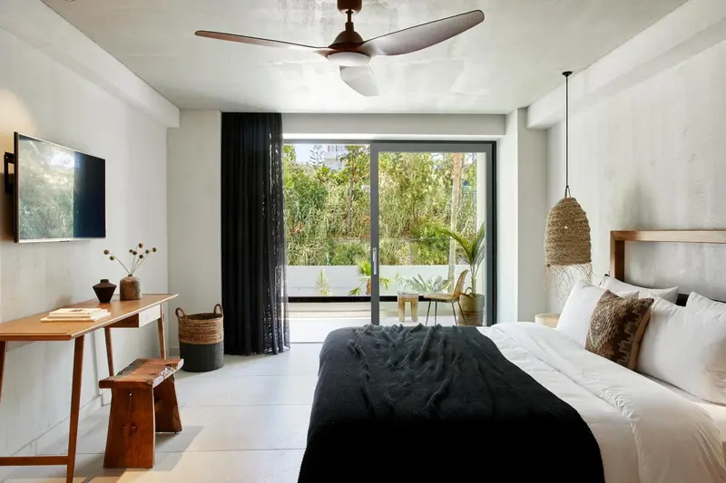 Une chambre lumineuse avec un grand lit et un accès à une terrasse.